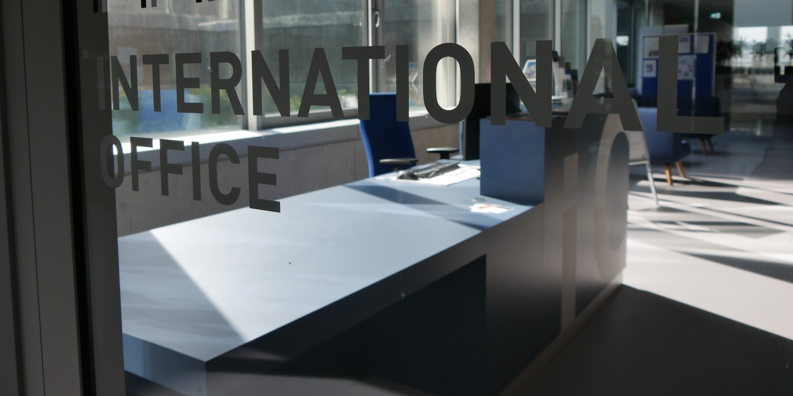 View through the entrance of the International Office, view of the glass with letters on it