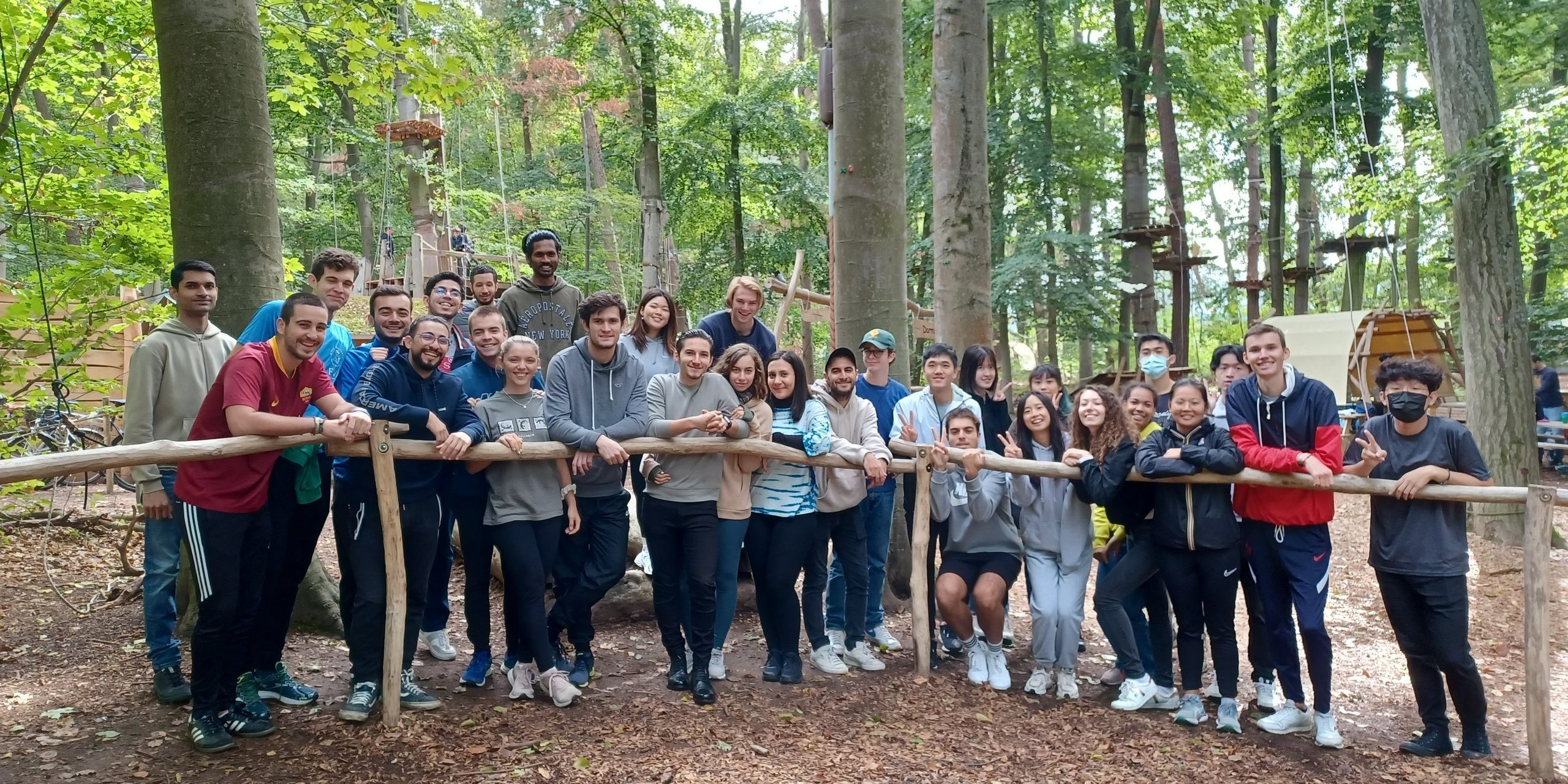 Eine Gruppe Studierender steht vor Bäumen im Kletterwald Darmstadt