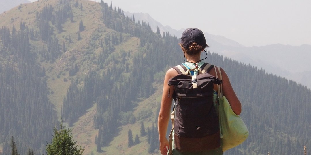 A student from behind walking along a hiking path