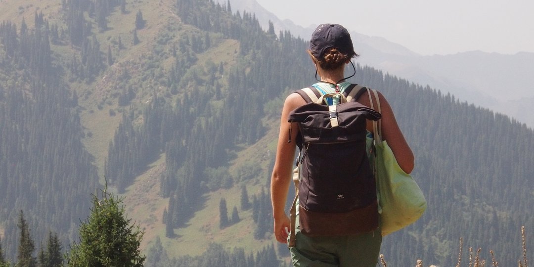 Eine Studentin von hinten, die auf einem Wanderweg läuft